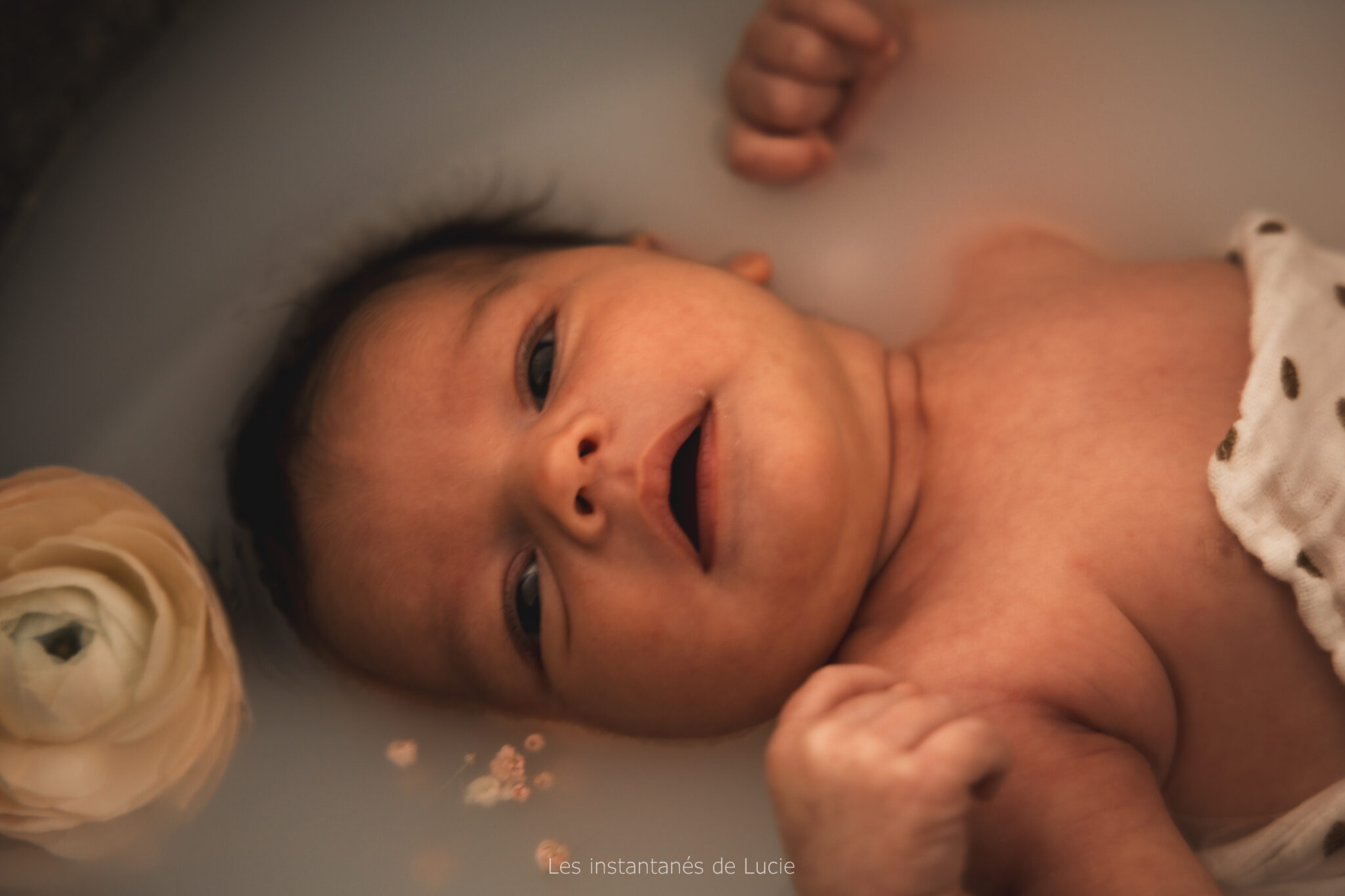 shooting nouveau né bain de lait, de l'eau, des fleurs, du lait et de la musique en fond sonore