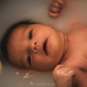 shooting nouveau né bain de lait, de l'eau, des fleurs, du lait et de la musique en fond sonore