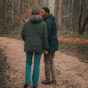 Un couple se promenant main dans la main et s'embrassant, pris en photo par Lucie Brisseau.